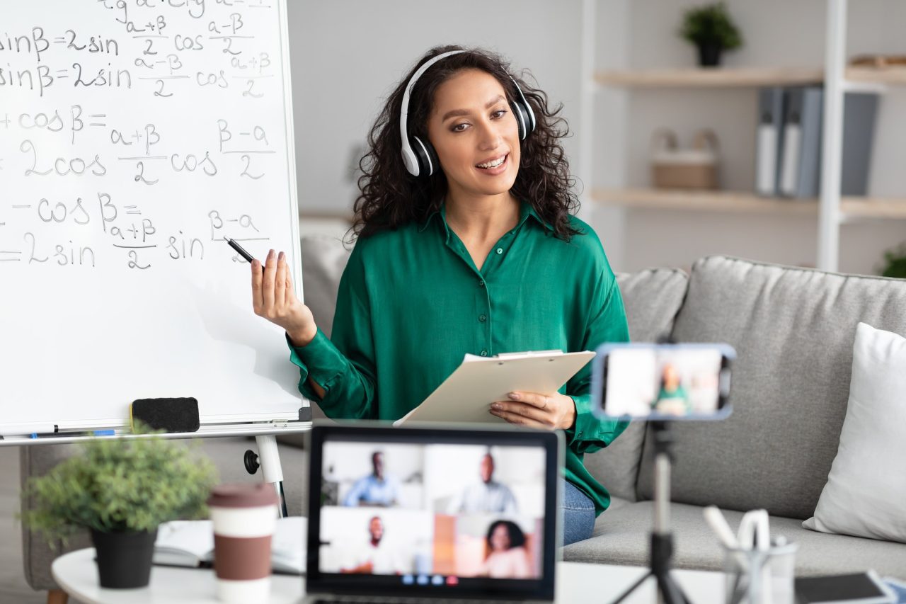 young teacher showing board giving virtual lecture to students